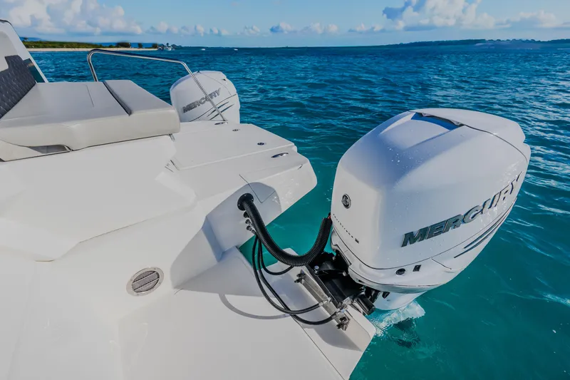 Slide: The Image of 2023 Aquila 36 Sport boat with Mercury outboard engines on clear blue water. - 15