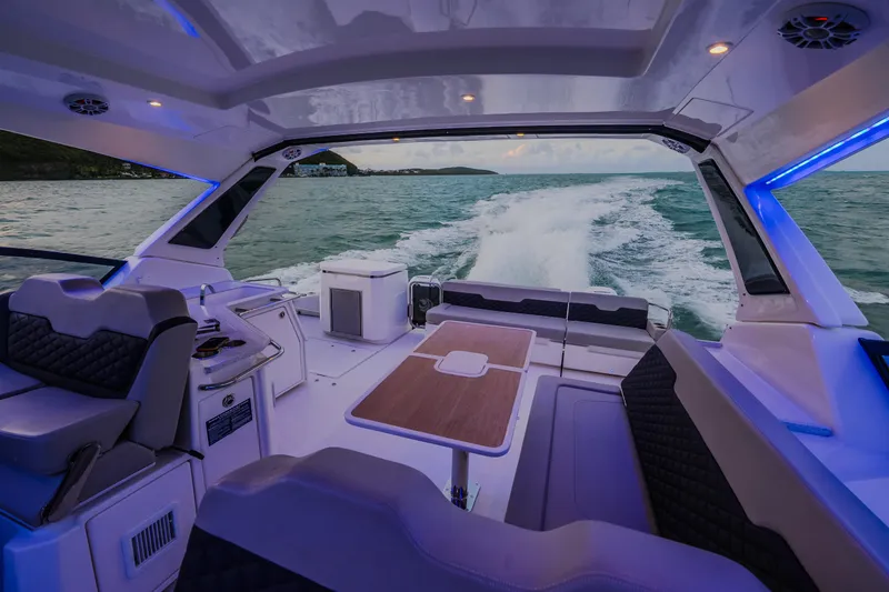 Slide: The Image of 2023 Aquila 36 Sport boat interior with seating and table, cruising on open water. - 57