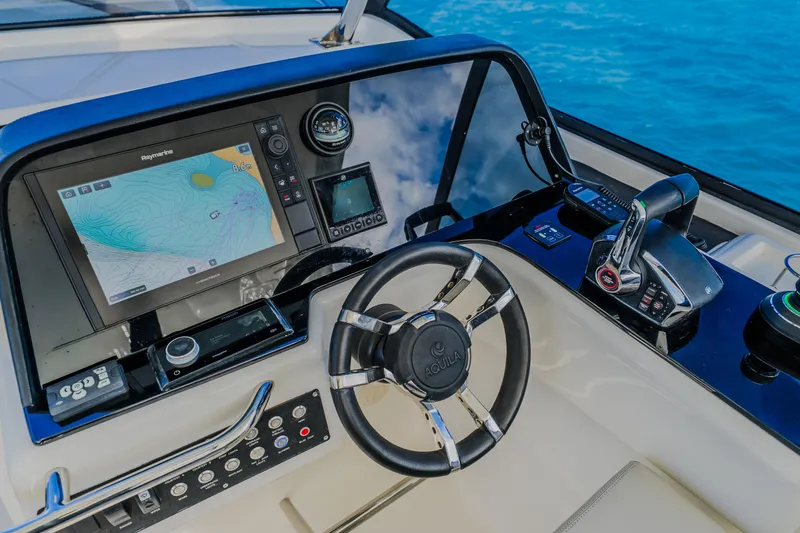 Slide: The Image of Control panel of 2023 Aquila 36 Sport boat with navigation display and steering wheel. - 37