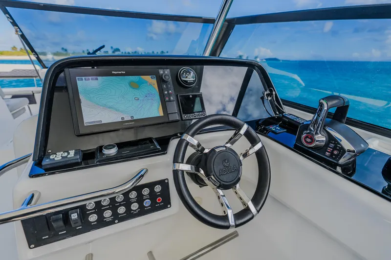Slide: The Image of Helm of 2023 Aquila 36 Sport boat with navigation display and controls. - 36