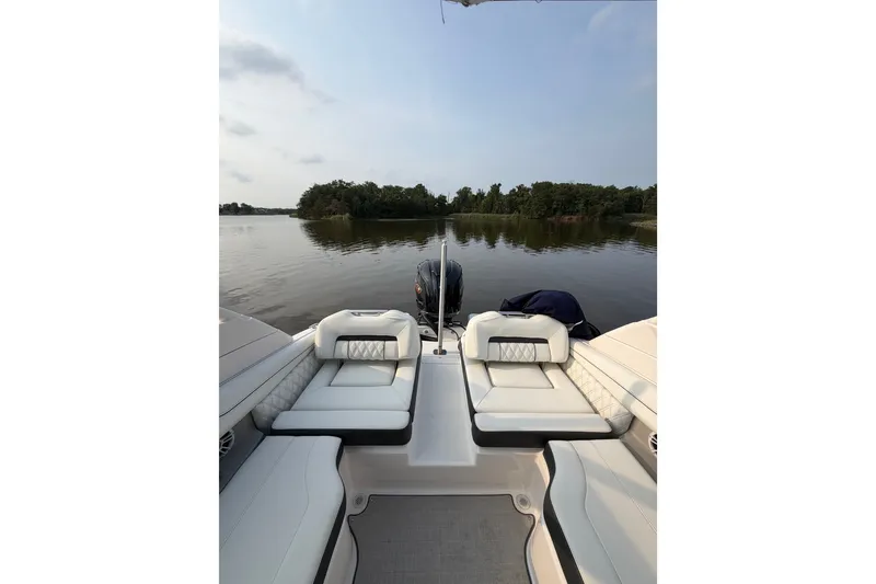 Slide: The Image of 2023 Regal LX2 boat interior with luxurious seating on a serene lake. - 4