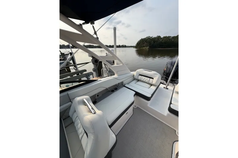 Slide: The Image of Luxurious 2023 Regal LX2 boat interior with plush seating on a serene lake. - 17