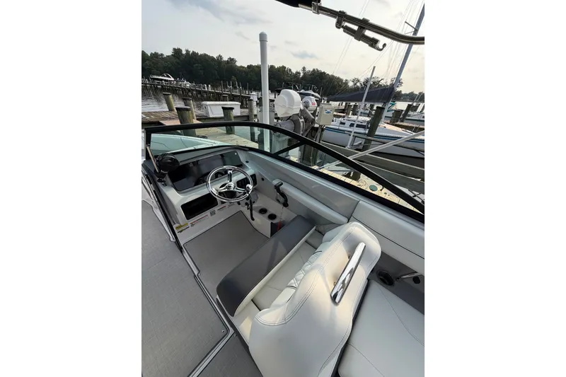 Slide: The Image of 2023 Regal LX2 boat interior with steering wheel, docked at marina. - 7