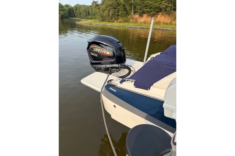Slide: The Image of 2023 Regal LX2 boat with Yamaha outboard motor on a calm lake. - 2