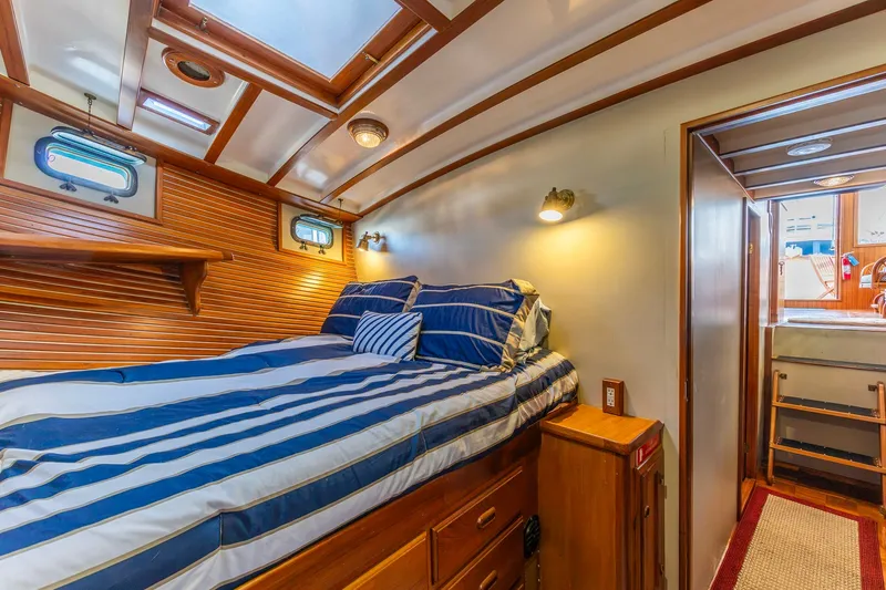 Slide: The Image of Cozy cabin interior of 1990 Kadey-Krogen 42 yacht with striped bedding and wooden accents. - 12