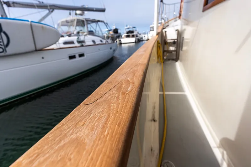 Slide: The Image of Kadey-Krogen 42 yacht, 1990 model, docked with wooden railing and nearby sailboat. - 14