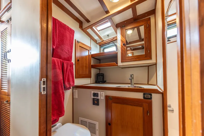 Slide: The Image of Interior of 1990 Kadey-Krogen 42 yacht bathroom with wooden cabinetry and red towels. - 46