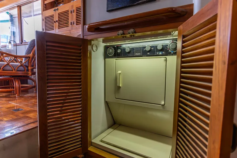 Slide: The Image of Laundry area inside a 1990 Kadey-Krogen 42 yacht, featuring a compact dryer. - 45