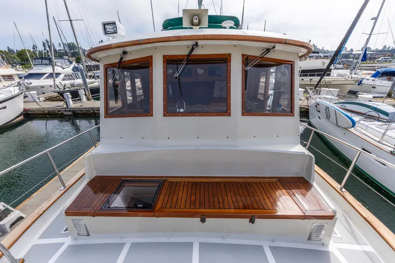 Slide: The Image of 1990 Kadey-Krogen 42 yacht docked at marina, featuring wooden deck and cabin windows. - 18