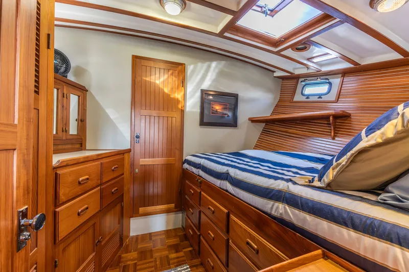 Slide: The Image of Cozy 1990 Kadey-Krogen 42 yacht cabin with wooden interior and striped bedding. - 11