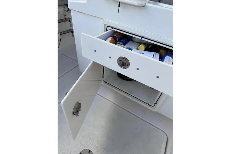 Slide: The Image of 2022 Pursuit S 268 Sport boat storage compartment with open drawer and cabinet. - 16