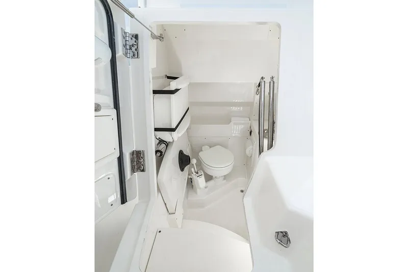 Slide: The Image of Manufacturer Provided Image: 2022 Pursuit S 268 Sport boat interior bathroom with toilet and storage shelves. - 43