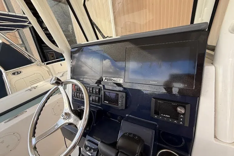 Slide: The Image of 2022 Pursuit S 268 Sport boat dashboard with steering wheel and electronic displays. - 13