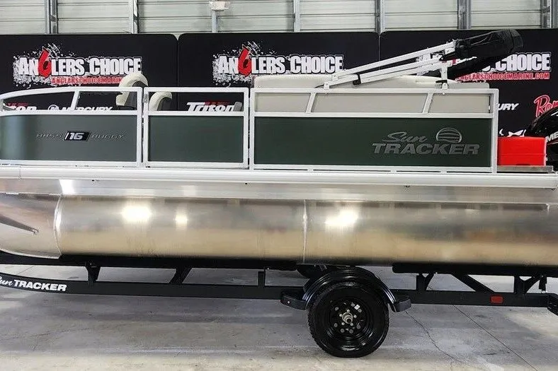 The Image of 2027 Sun Tracker Bass Buggy 16 XL Select pontoon boat on trailer in showroom. - 1