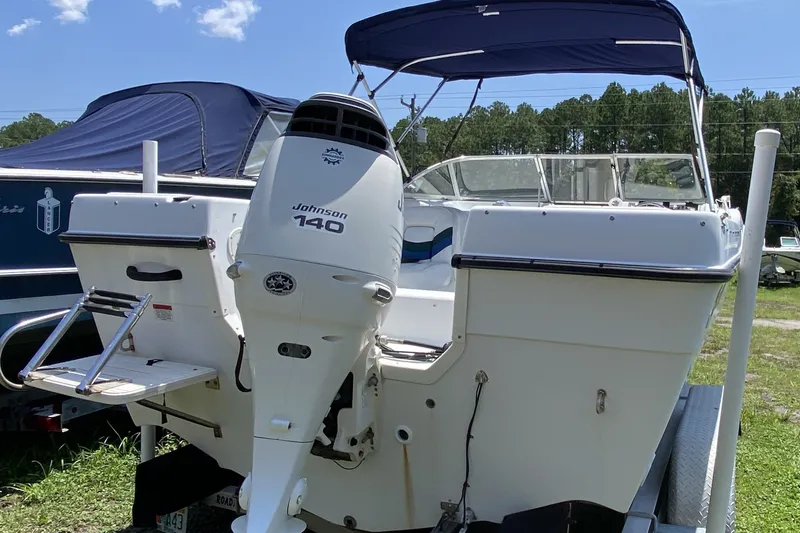 Slide: The Image of 2000 Seaswirl Striper 2100 boat with Johnson 140 outboard motor, parked on trailer. - 2