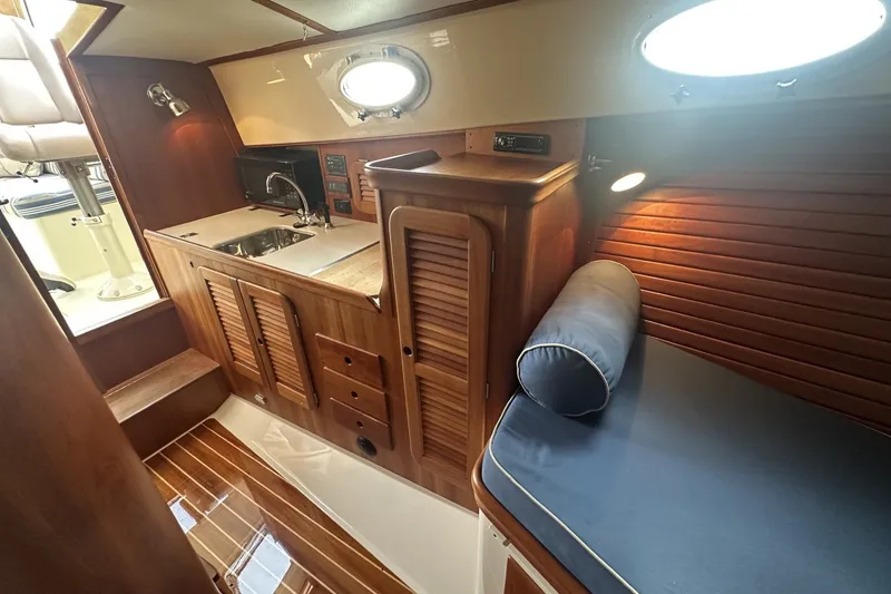 Slide: The Image of 2005 Hinckley Picnic Boat 36 EP interior with wooden cabinetry and seating area. - 19