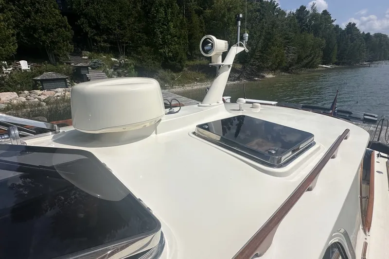 Slide: The Image of 2005 Hinckley Picnic Boat 36 EP on a serene lake with lush greenery. - 28