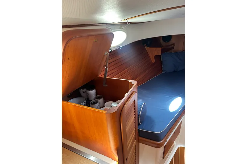 Slide: The Image of Interior of 2005 Hinckley Picnic Boat 36 EP with wooden cabinetry and cozy seating area. - 24