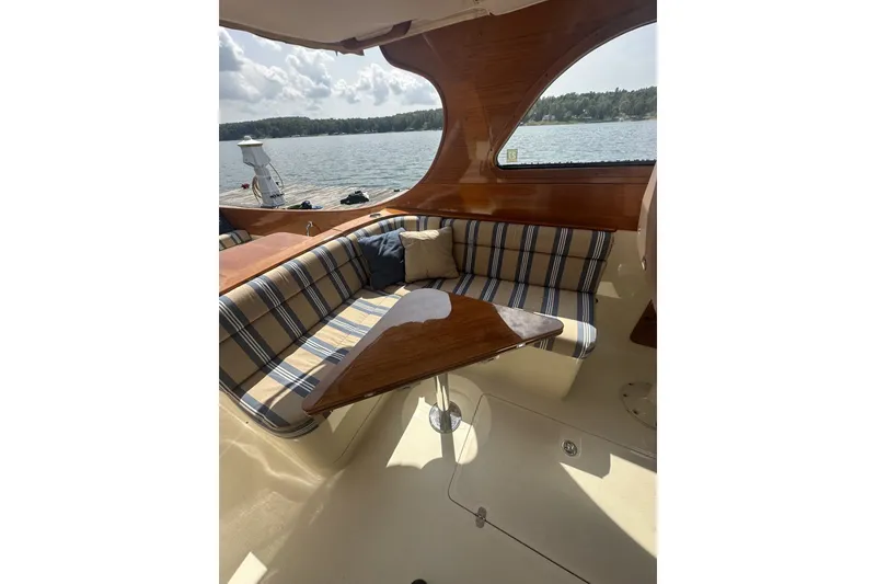 Slide: The Image of Interior of 2005 Hinckley Picnic Boat 36 EP with striped seating and wooden table. - 13