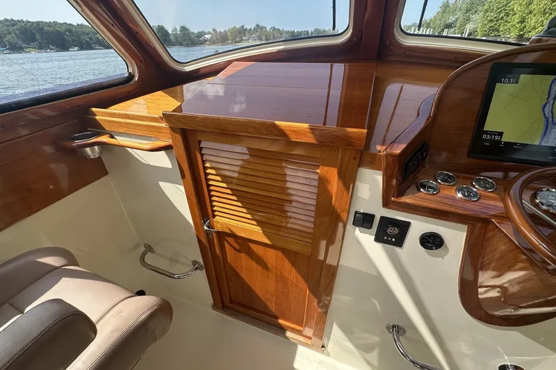 Slide: The Image of Interior of 2005 Hinckley Picnic Boat 36 EP with polished wood finish and navigation controls. - 17
