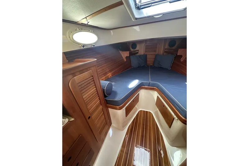 Slide: The Image of 2005 Hinckley Picnic Boat 36 EP cabin with wooden interior and blue cushions. - 23