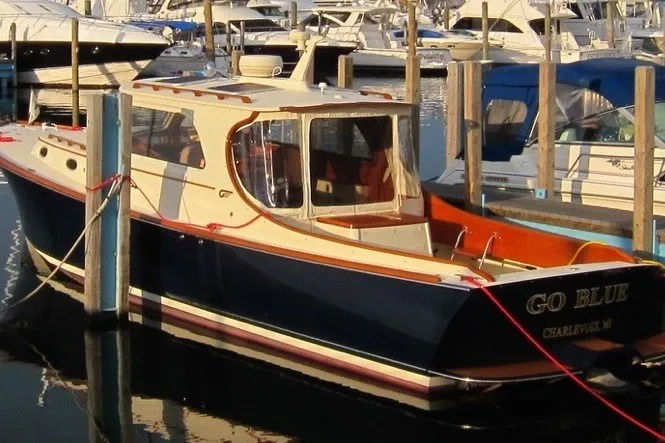 Slide: The Image of 2005 Hinckley Picnic Boat 36 EP docked in a marina, featuring classic design and elegant lines. - 36