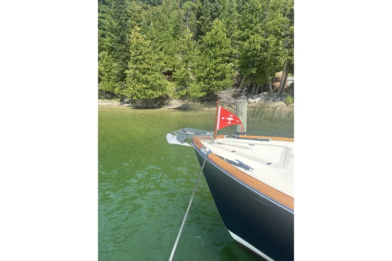 Slide: The Image of Hinckley Picnic Boat 36 EP (2005) anchored near lush green shoreline. - 34