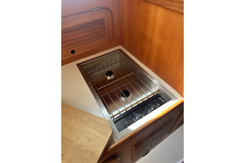 Slide: The Image of Compact kitchen stove in 2005 Hinckley Picnic Boat 36 EP, featuring wooden cabinetry. - 22