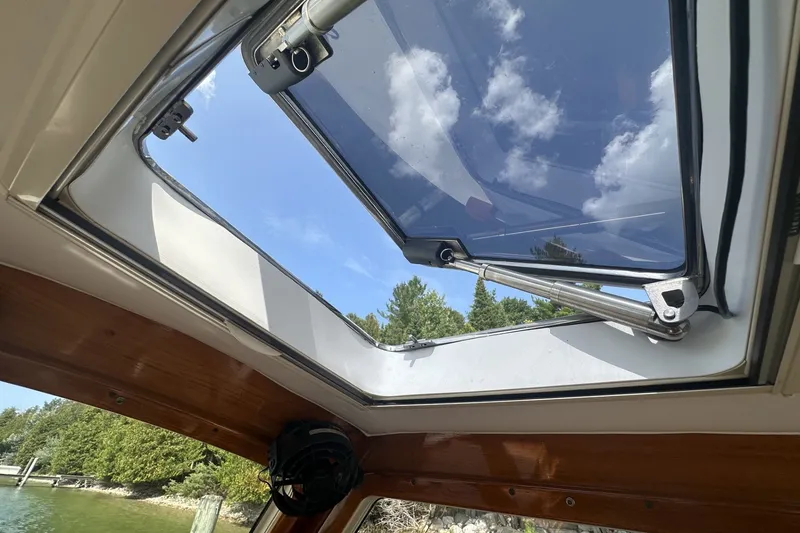 Slide: The Image of Open sunroof on 2005 Hinckley Picnic Boat 36 EP, showcasing clear sky and lush greenery. - 16