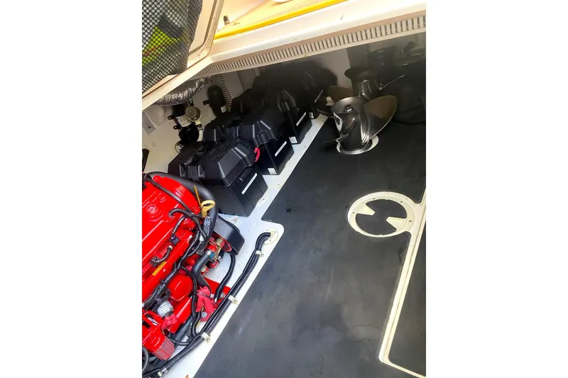 Slide: The Image of Engine compartment of a 2008 Contender 38 Express boat, featuring batteries and a red engine. - 59