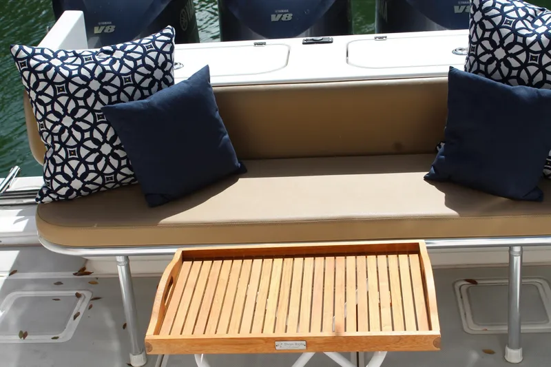 Slide: The Image of 2008 Contender 38 Express boat seating with decorative pillows and wooden tray. - 30