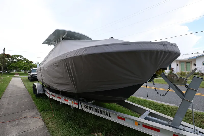 Slide: The Image of 2024 Dusky 278 XFY boat covered on trailer, parked on roadside. - 21