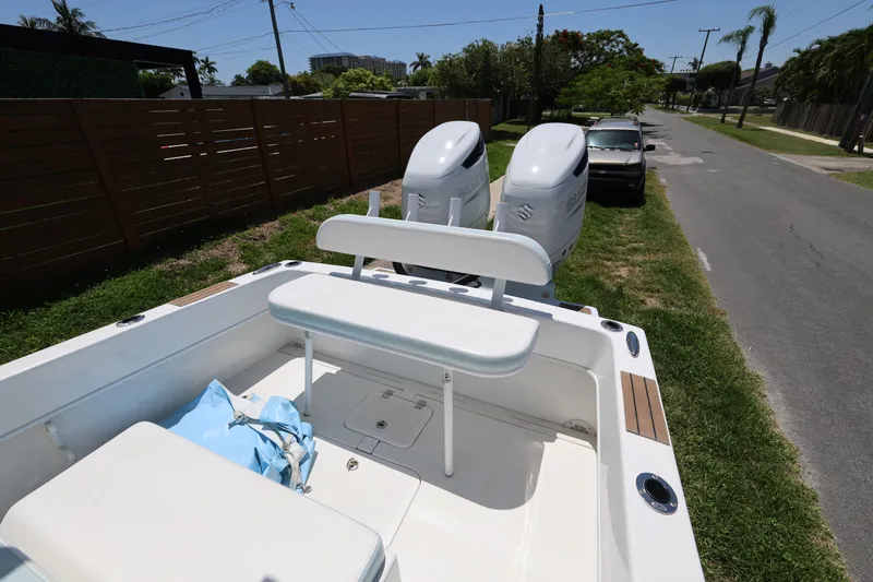 Slide: The Image of 2024 Dusky 278 XFY boat with dual Suzuki outboard motors parked on grass beside a road. - 17