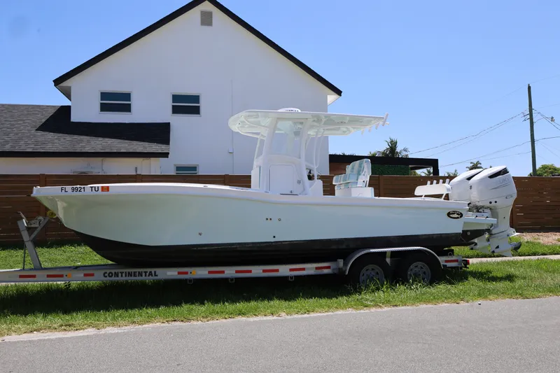 The Image of 2024 Dusky 278 XFY boat on trailer, parked in front of a house. - 1