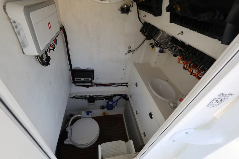 Slide: The Image of 2024 Dusky 278 XFY boat interior with toilet, sink, and electrical components. - 15