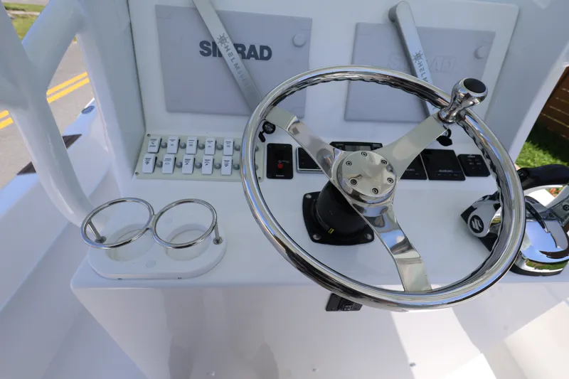 Slide: The Image of Steering console of 2024 Dusky 278 XFY boat with controls and cup holders. - 11