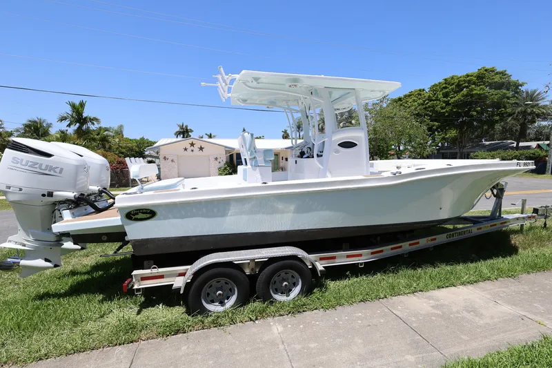 Slide: The Image of 2024 Dusky 278 XFY boat on trailer with Suzuki engine, parked outdoors. - 6