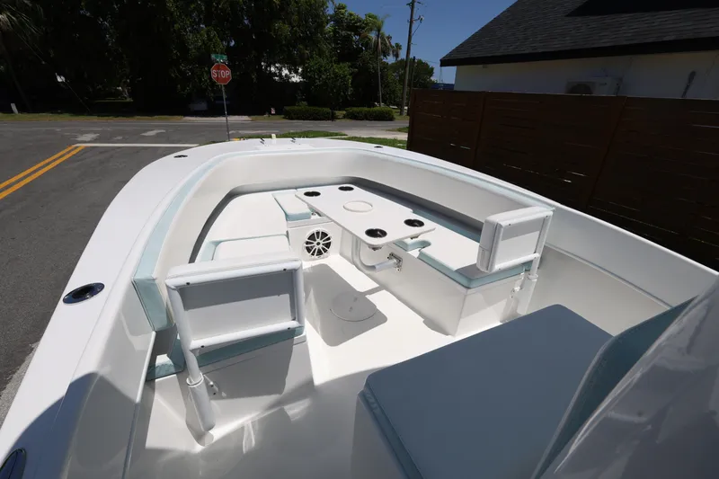 Slide: The Image of 2024 Dusky 278 XFY boat interior with seating and table, parked on a street. - 13
