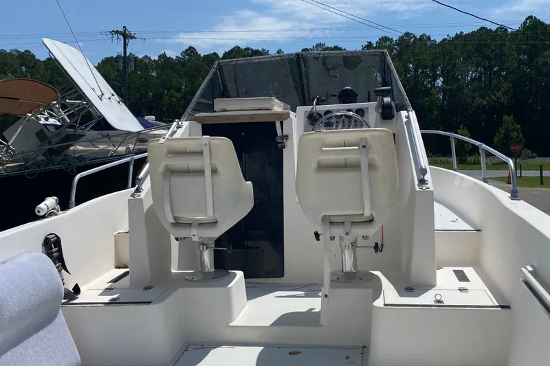 Slide: The Image of Interior view of a 1991 Horizon 204 boat with dual white seats and steering console. - 5