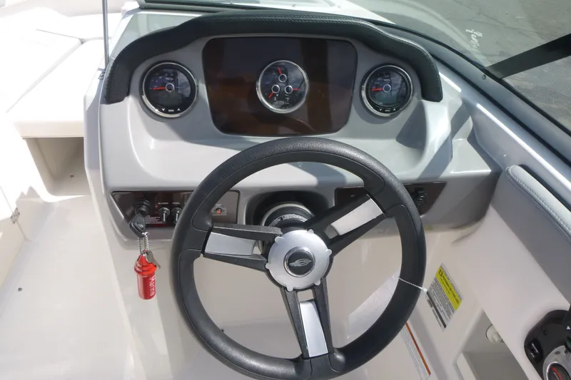 Slide: The Image of 2021 Chaparral 23 SSi boat dashboard with steering wheel and gauges. - 9