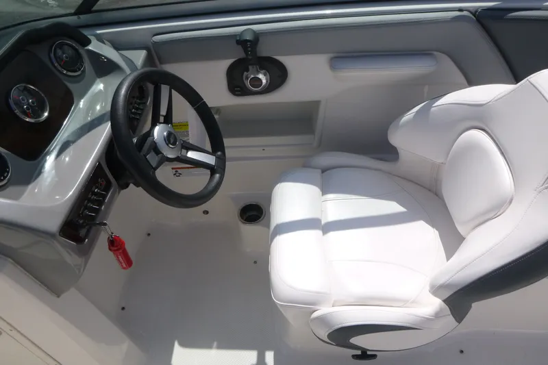 Slide: The Image of 2021 Chaparral 23 SSi boat cockpit with steering wheel and white captain's seat. - 8