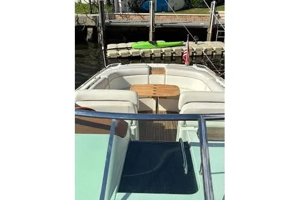 Slide: The Image of 2006 Chris Craft Corsair Heritage boat with white seating and wooden accents at a dock. - 14