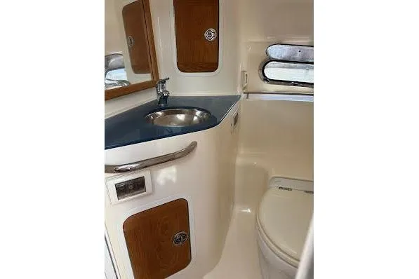 Slide: The Image of 2006 Chris Craft Corsair Heritage boat bathroom with sink, toilet, and wooden cabinets. - 26