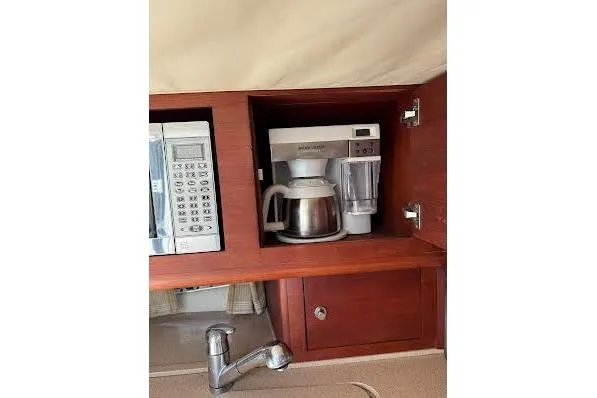 Slide: The Image of 2006 Chris Craft Corsair Heritage kitchen with microwave, coffee maker, and wooden cabinetry. - 16