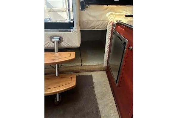 Slide: The Image of 2006 Chris Craft Corsair Heritage interior with wooden steps and compact kitchenette. - 32