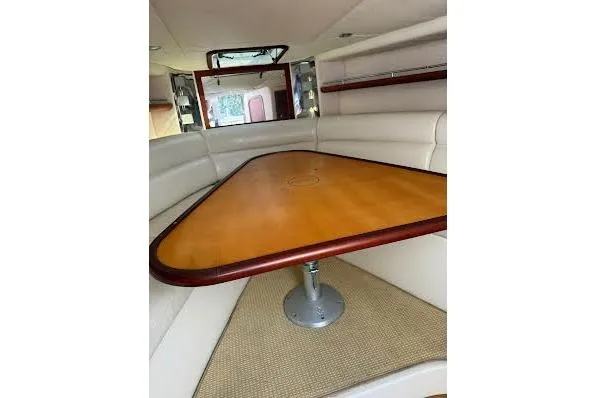 Slide: The Image of 2006 Chris Craft Corsair Heritage interior with triangular wooden table and white seating. - 21