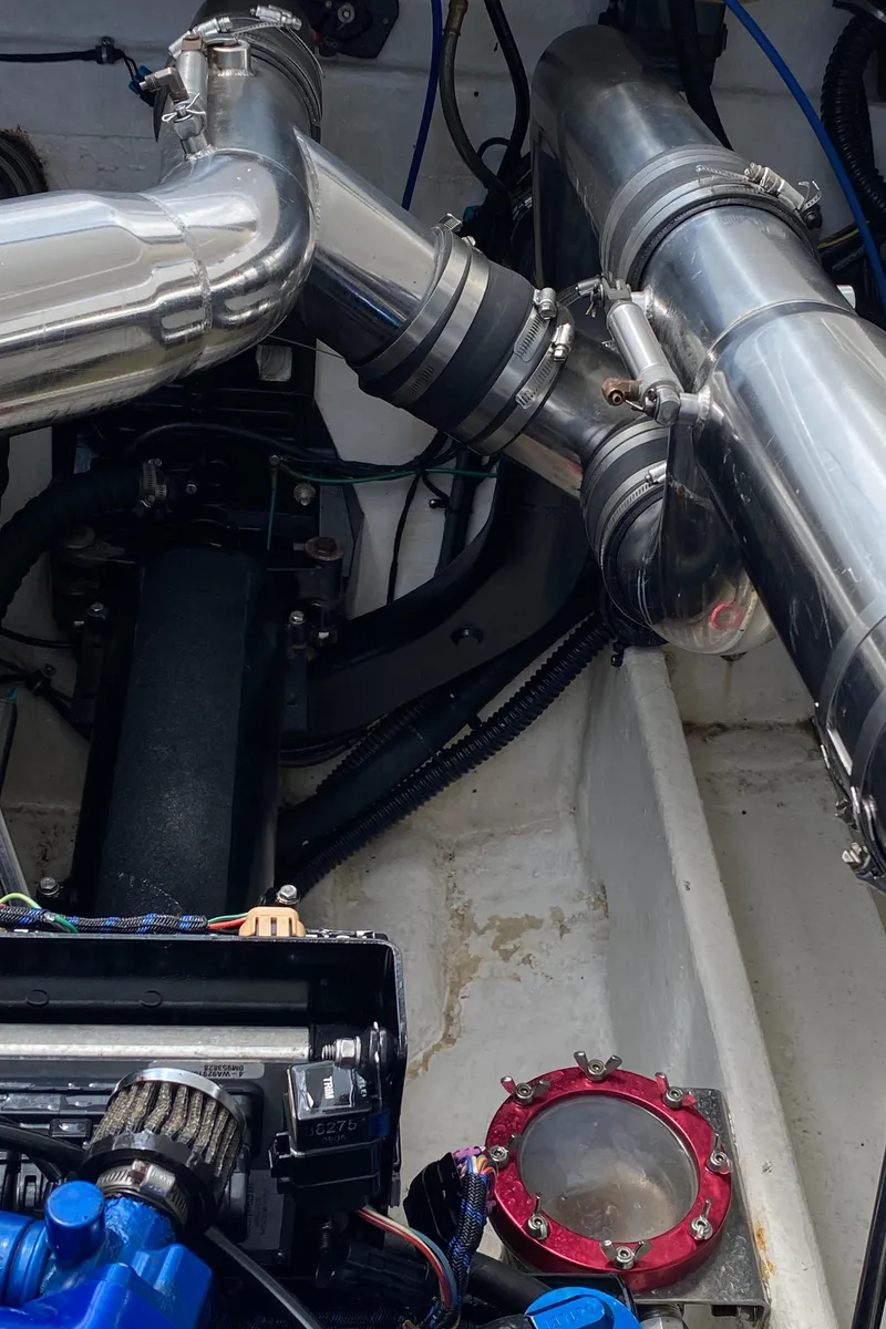 Slide: The Image of Engine components of a 2006 Fountain 42 Executioner boat, featuring metallic pipes and mechanical parts. - 19