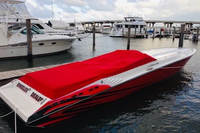 Slide: The Image of 2006 Fountain 42 Executioner speedboat with red cover docked at marina. - 6