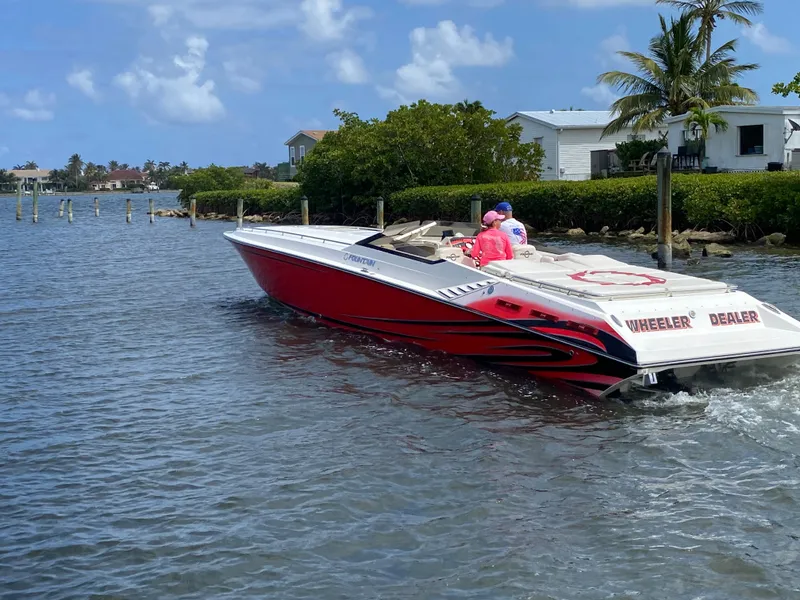 Slide: The Image of 2006 Fountain 42 Executioner speedboat cruising near waterfront homes and palm trees. - 1