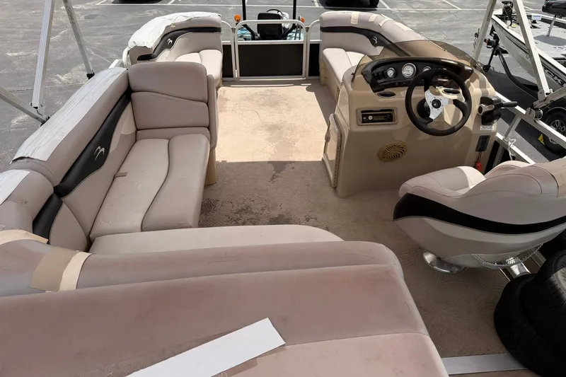 Slide: The Image of Interior of a 2011 Bennington 20SLi pontoon boat with beige seating and steering console. - 13